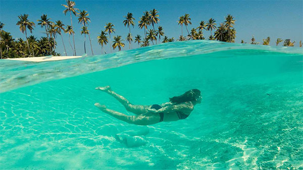 Adult swimming in the waves in the Maldives.
