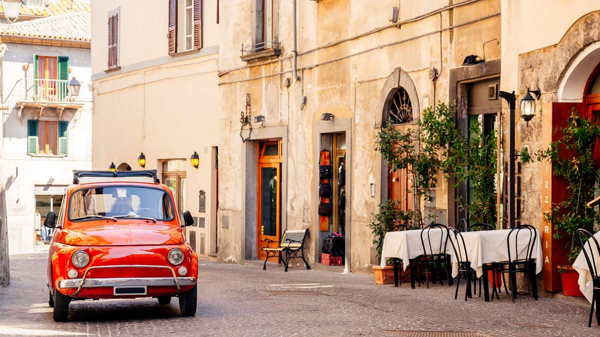 Red vintage car on the cobbled streets of Rome.