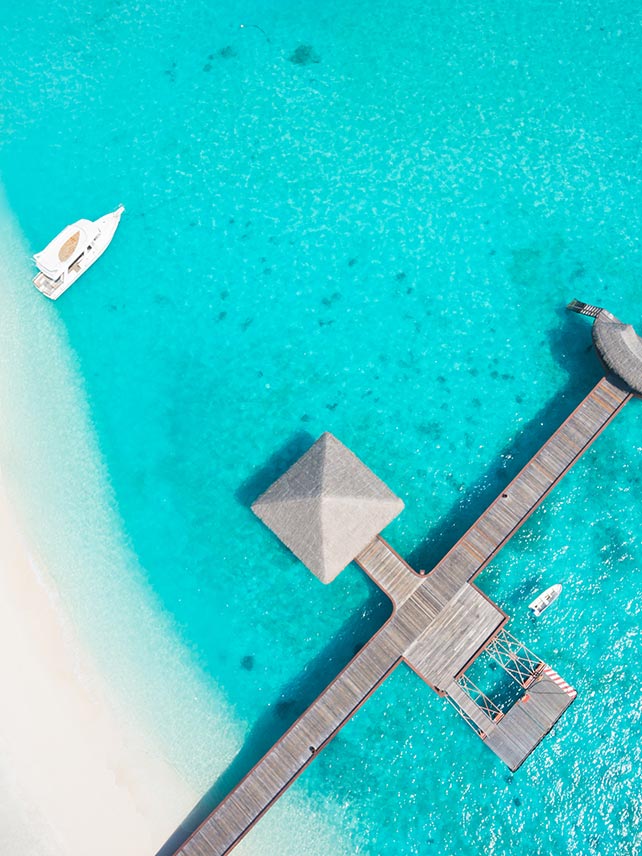 Aerial view of jetty over a turquoise ocean in the Maldives. © amriphoto.