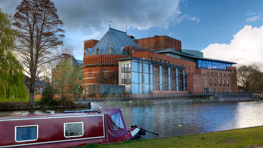 Narrowboat moored on the River Avon by the Royal Shakespeare Company theatre, Stratford upon Avon, UK. ©Andy Roland.