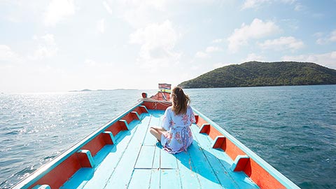 Young woman sitting on blue boat.