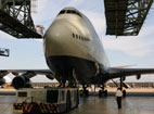A Boeing 747 taxis into an aircraft hanger.