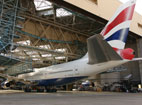 A Boeing 747 taxis into an aircraft hanger.