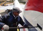 An engineer cleans the tail fin of a BA aircraft.