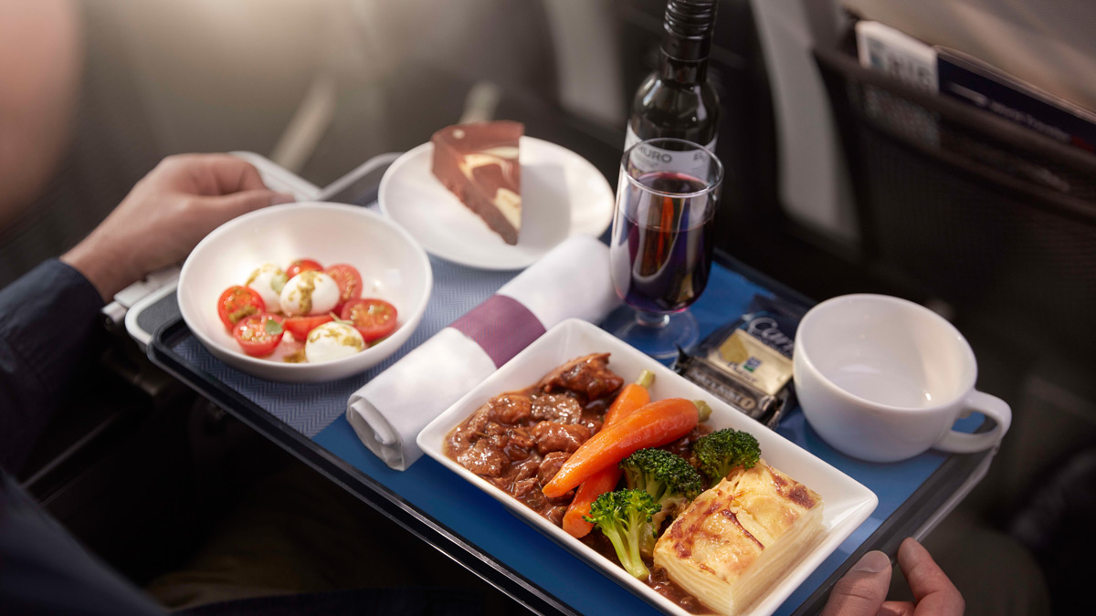 World Traveller Plus dinning tray with food and wine