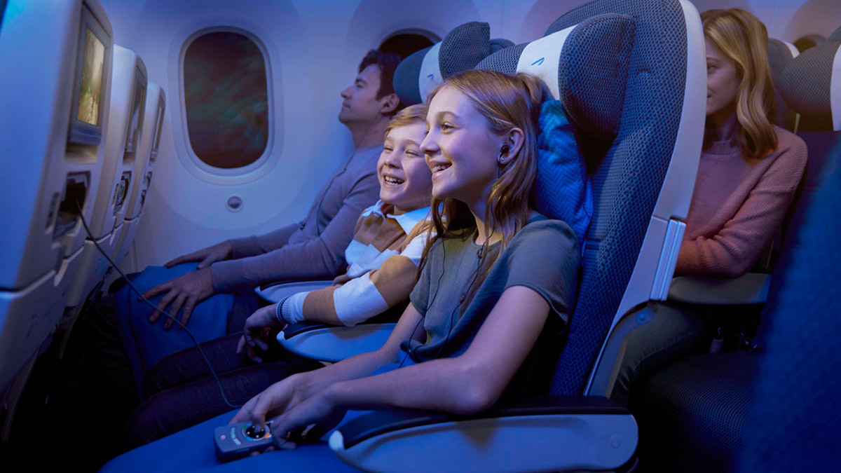 Niños en World Traveller viendo películas en el sistema de entretenimiento a bordo.
