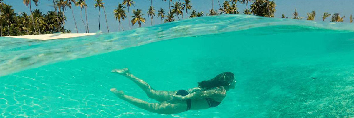 Adult swimming in the waves in the Maldives.
