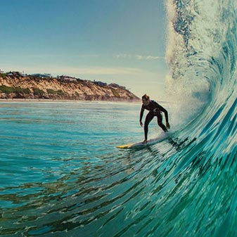 Homme faisant du surf sur la côte californienne.