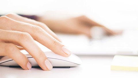 Primer plano de las manos de una mujer utilizando un ratón de ordenador.