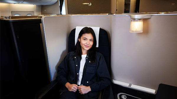 Emma Raducanu sitting in seat on aircraft.