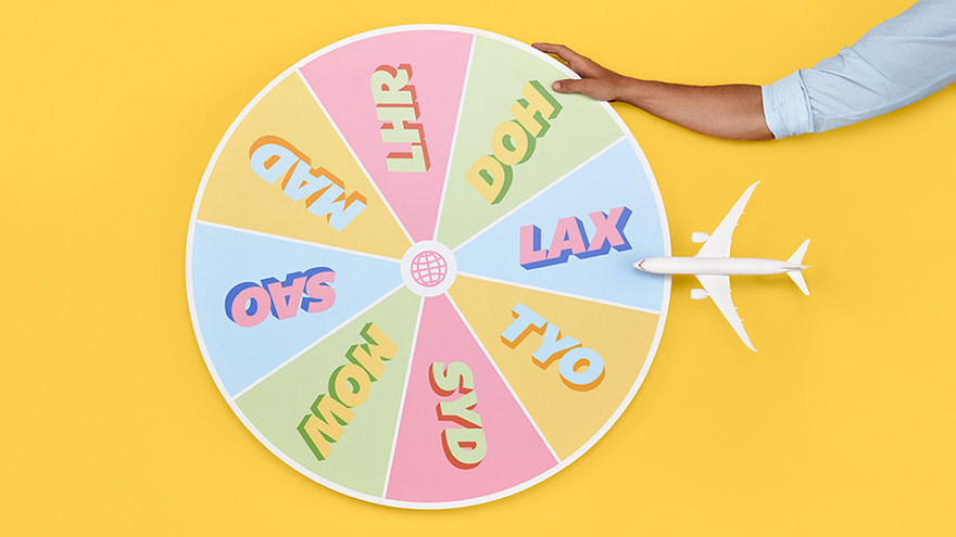 Wheel of airport names spun around by woman's hand.