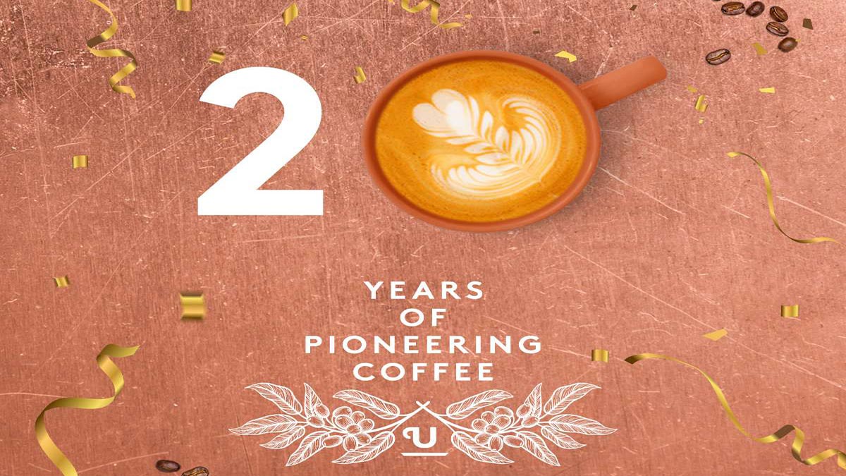 Copper background with coffee cup and 20th Anniversary lock up.