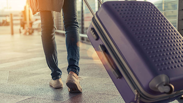 Viaggiatore con valigia in aeroporto.