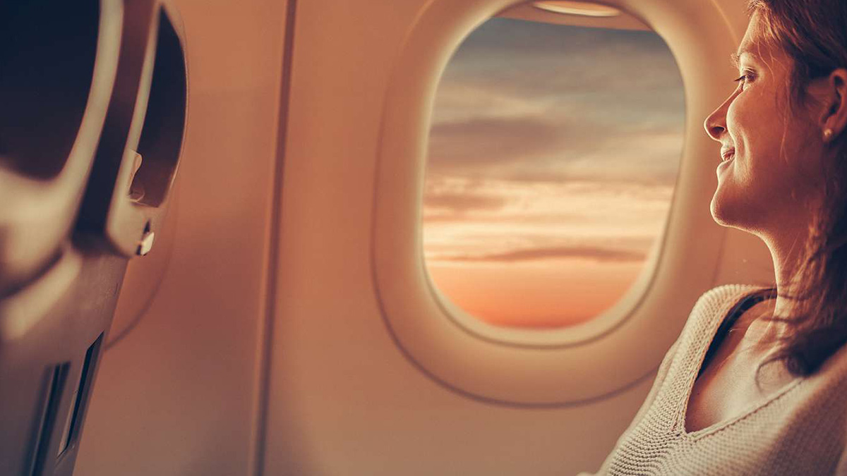 Mulher jovem a viajar num avião.