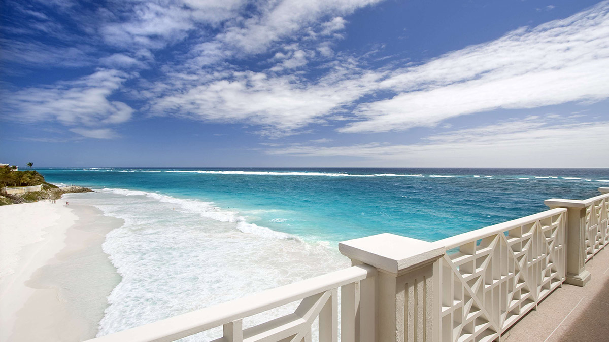 The view from a balcony in Barbados of a quiet beach.