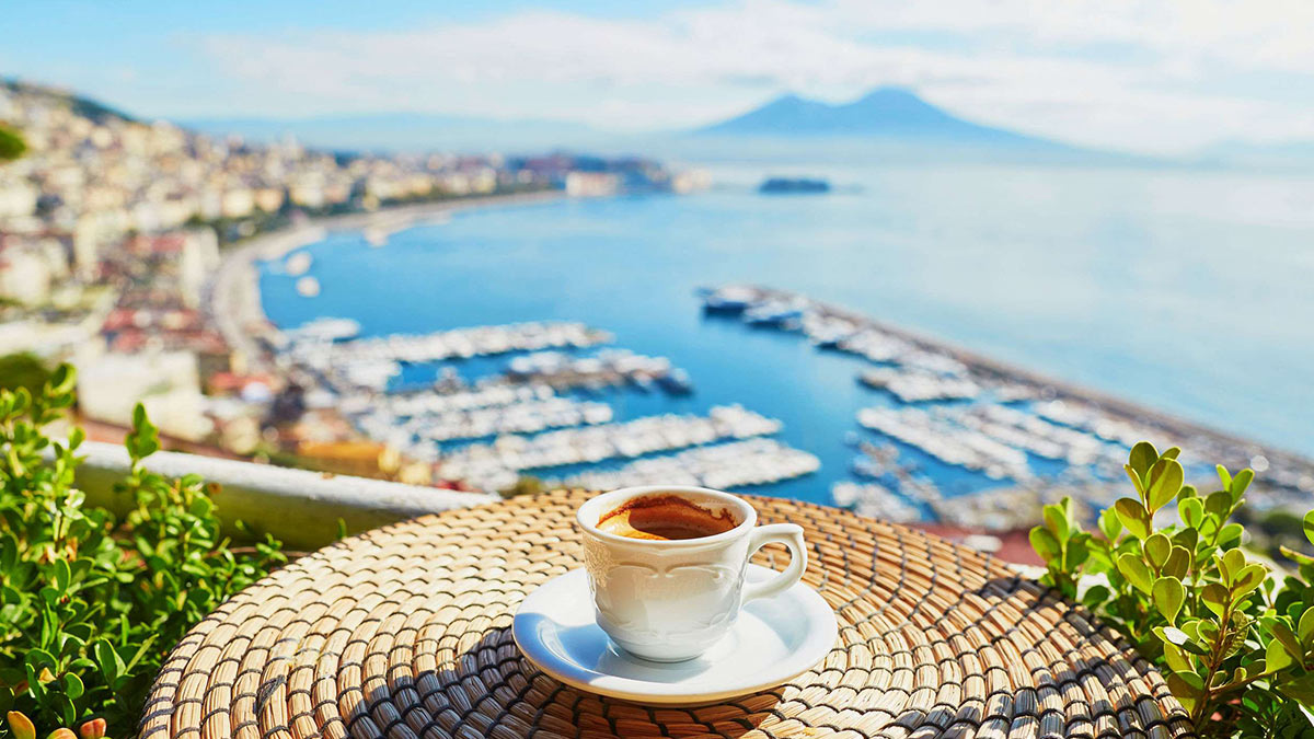 Tasse mit frischem Espresso in einem Café mit Blick auf den Vesuv in Neapel, Kampanien, Süditalien.