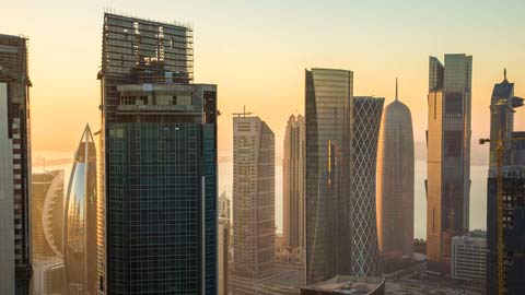 Doha cityscape with tall modern skyscrapers at dusk.