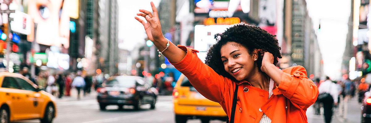 Lady hailing a taxi in New York City, USA.