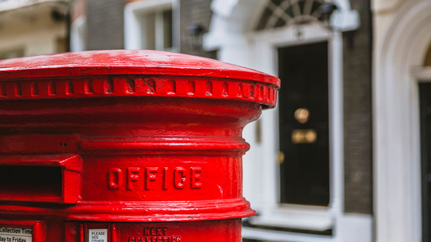 Close up red pillar box su London street.