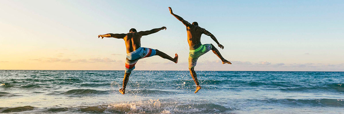 Adults jumping in the sea.