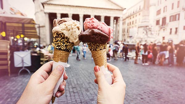 Deux mains tenant des cônes de crème glacée.