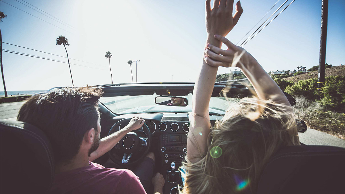 Couple driving on a convertible car.