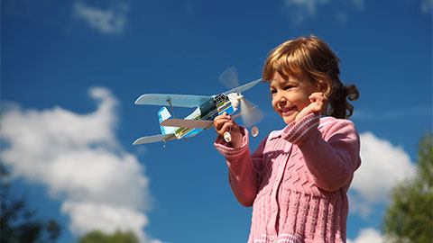 おもちゃの飛行機で遊ぶ少女。