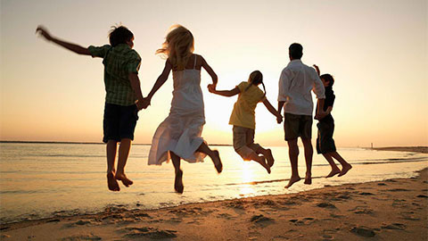 Une famille sautant sur une plage.
