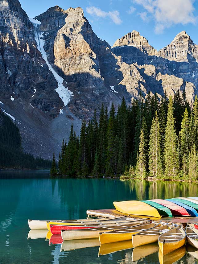 Fahren Sie mit dem Kanu über den strahlend blauen Lake Louise © Erik Pronske / Getty.