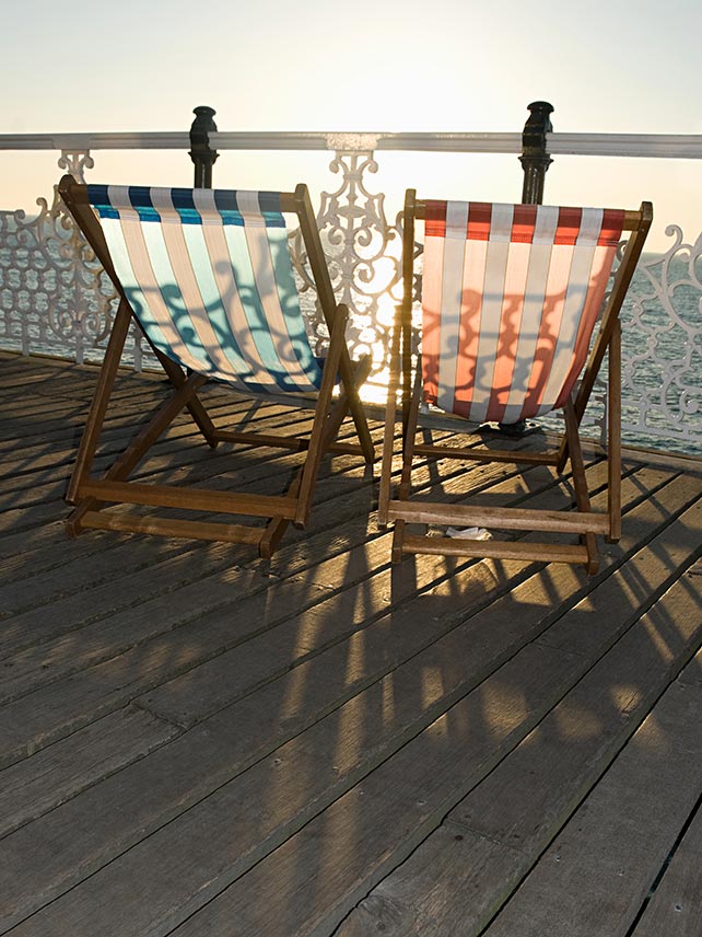 Sillas de playa tradicionales en la costa de Brighton. © Image Source.