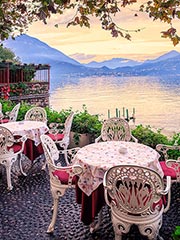 Mesas en la ribera del lago de Como, con vistas a los Alpes al atardecer ©Xantana.