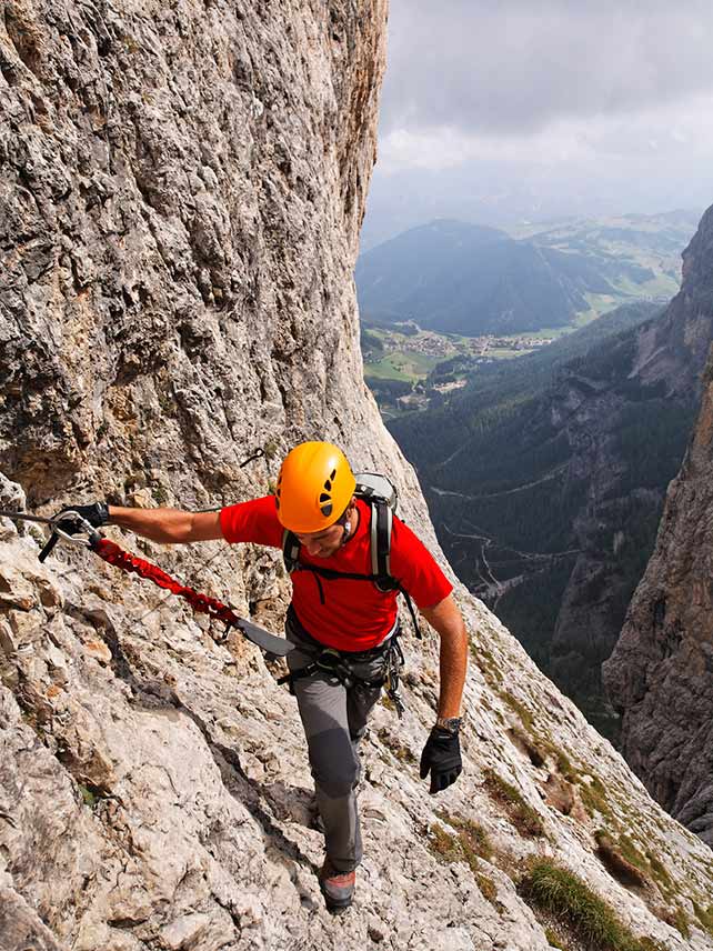 Uomo che si arrampica sulla Brigata Tridentina Via Ferrata, Gruppo del Sella, Dolomiti, Italia ©Mike Randolph.