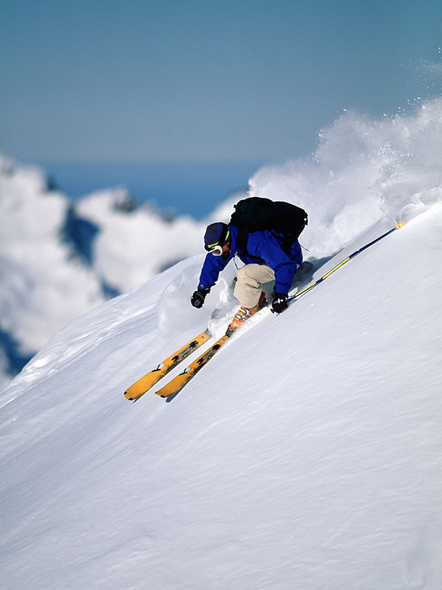 Uno sciatore raggiunge le piste ad Alpe-d’Huez, Vaujany © Ross Woodhall/Alamy
