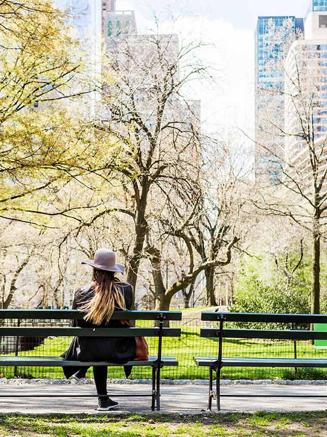 Woman sitting on a bench in Central Park. © Astrakan Images.