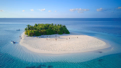 Uninhabited island for day trips with palm trees, bushes, sandy beach all around, offshore coral reef, Ari atoll, Indian Ocean, Maldives.