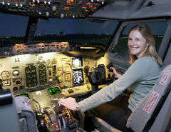 Donna seduta nella cabina di guida di un simulatore di volo.